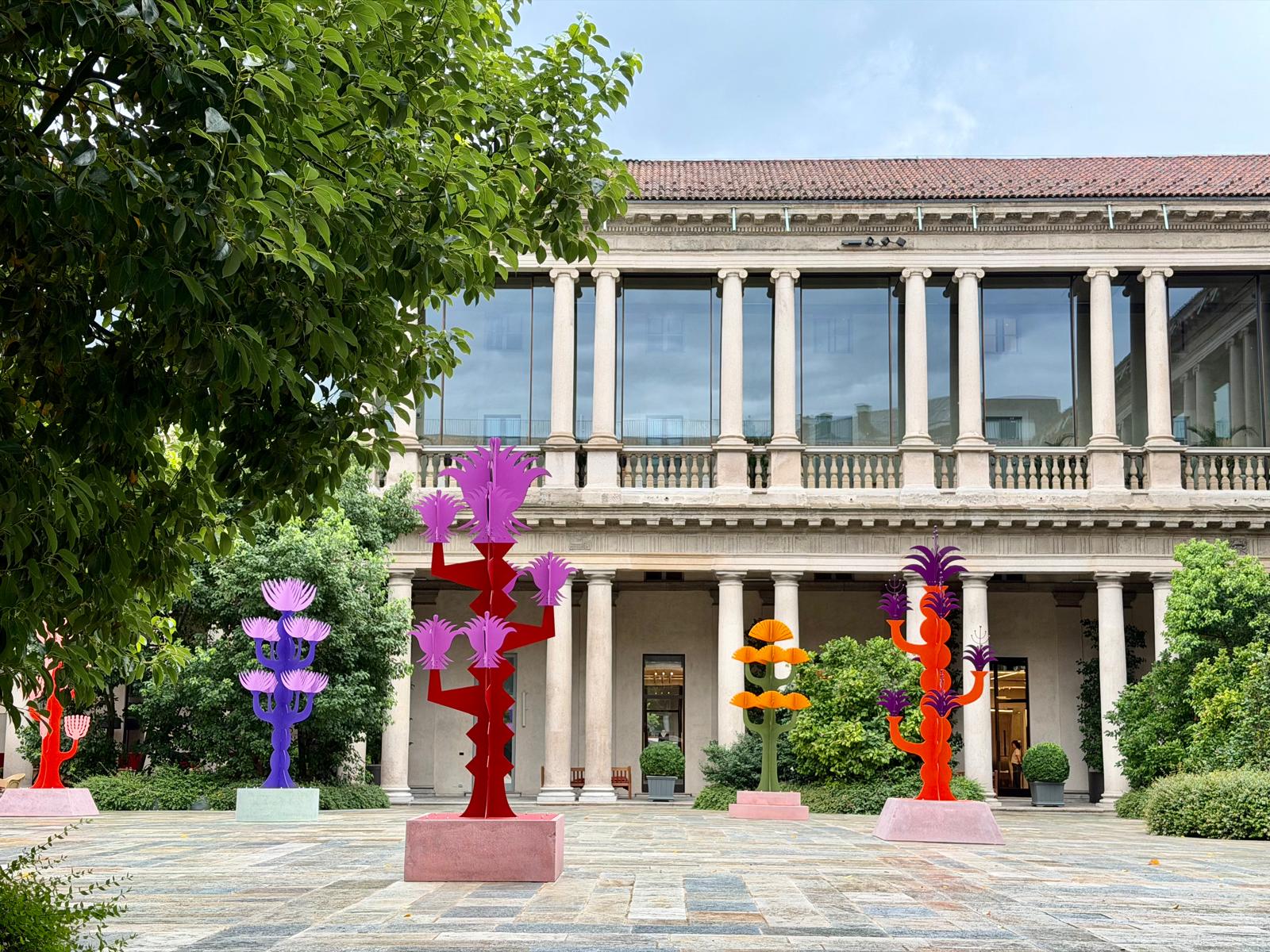 The historic courtyard of the stunning Portrait Milano, transformed during our visit by Agostino Iacurci's vibrant installation, Arcipelago Botanico.